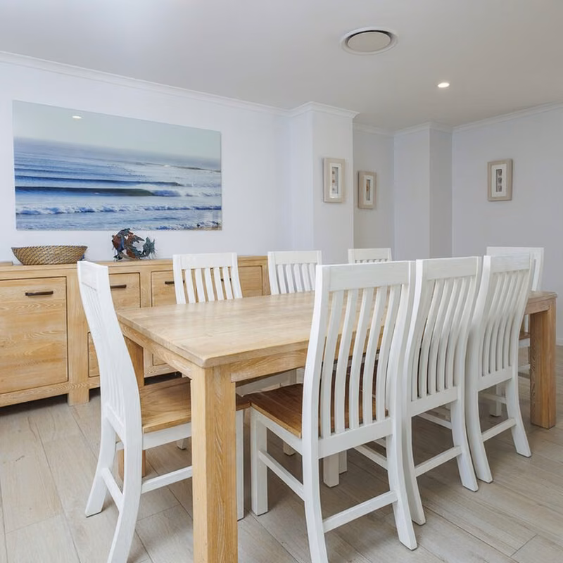Instagram post by The Village at Burleigh, tile 1 Penthouse dining room with a long timber table and surf artwork at The Village at Burleigh, Burleigh Heads