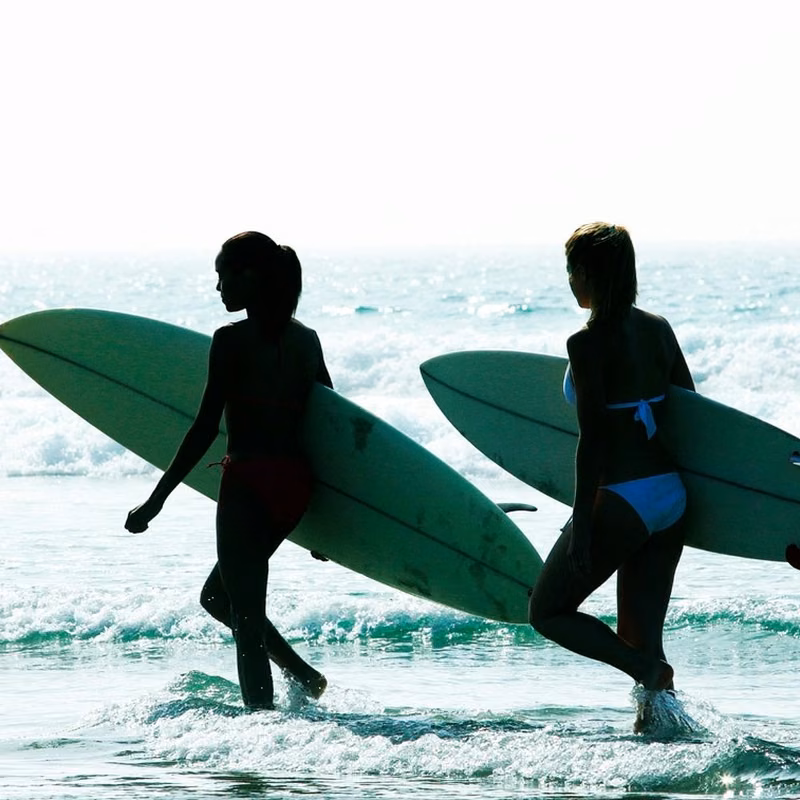 Instagram post by The Village at Burleigh, tile 6 Two surfers carrying their boards into the waves at Burleigh Heads, Gold Coast